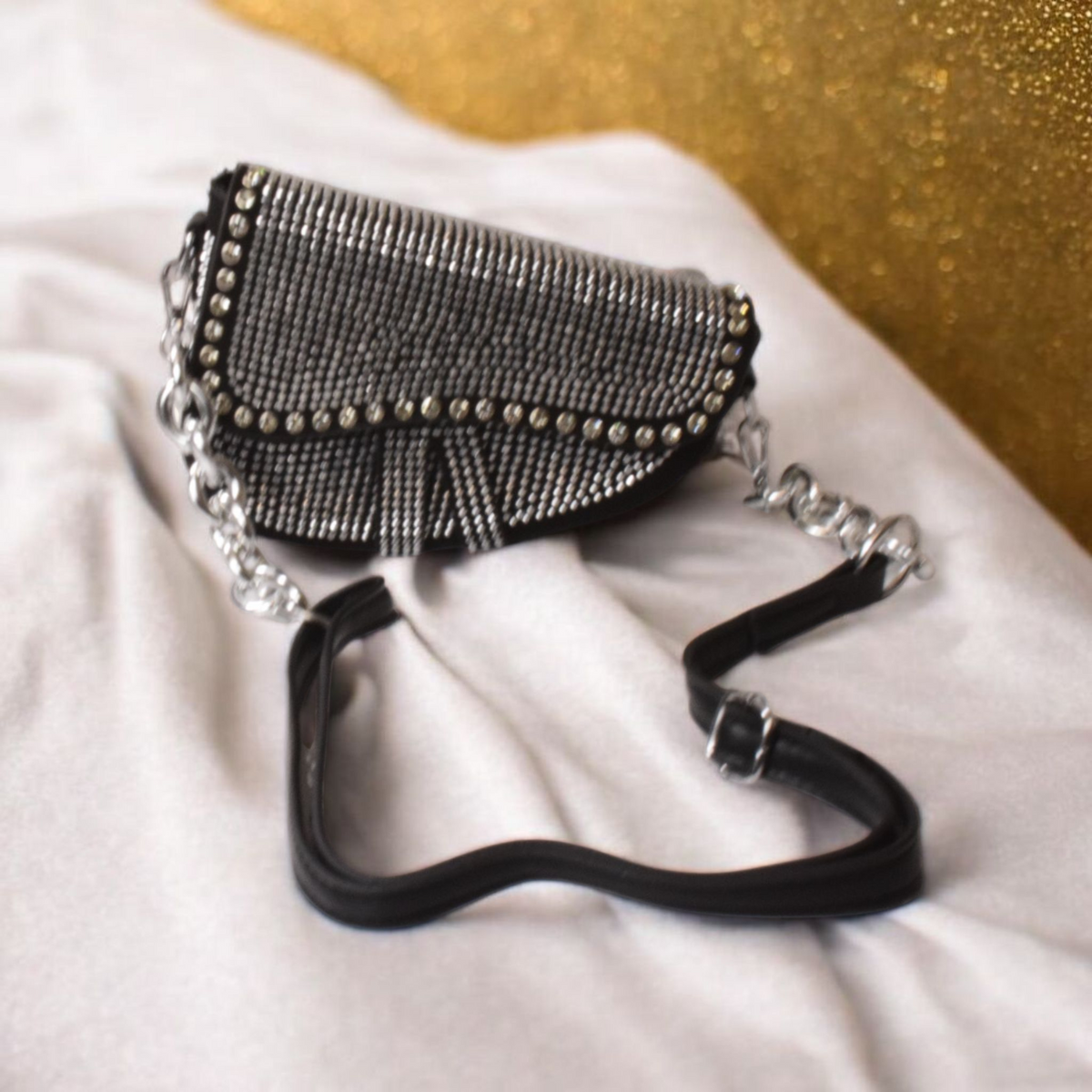 Close-up view of the sparkling rhinestone texture and metallic chain detail on the Zera bag.