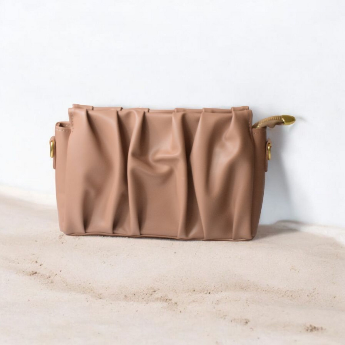 Brown clutch bag on a light beige surface with a white background