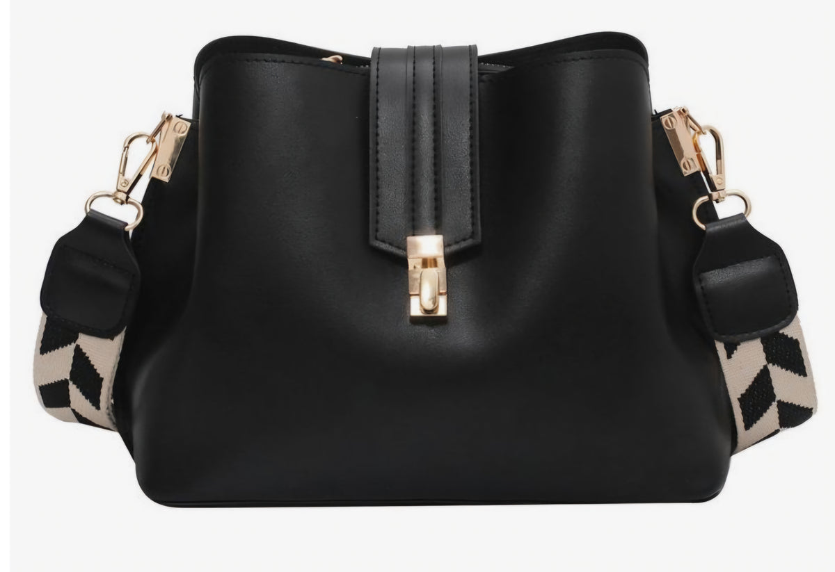 Black bucket bag with a geometric pattern on the strap and a metallic clasp closure