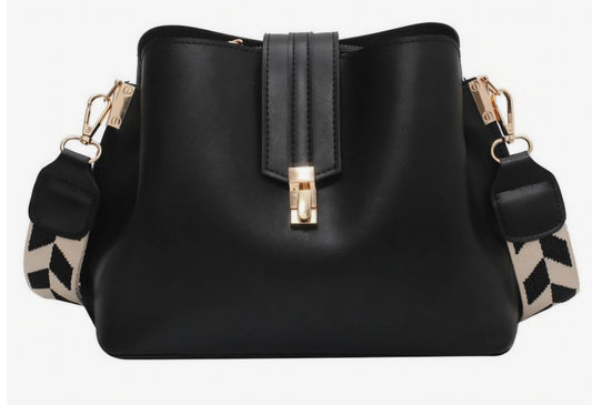 Black bucket bag with a geometric pattern on the strap and a metallic clasp closure