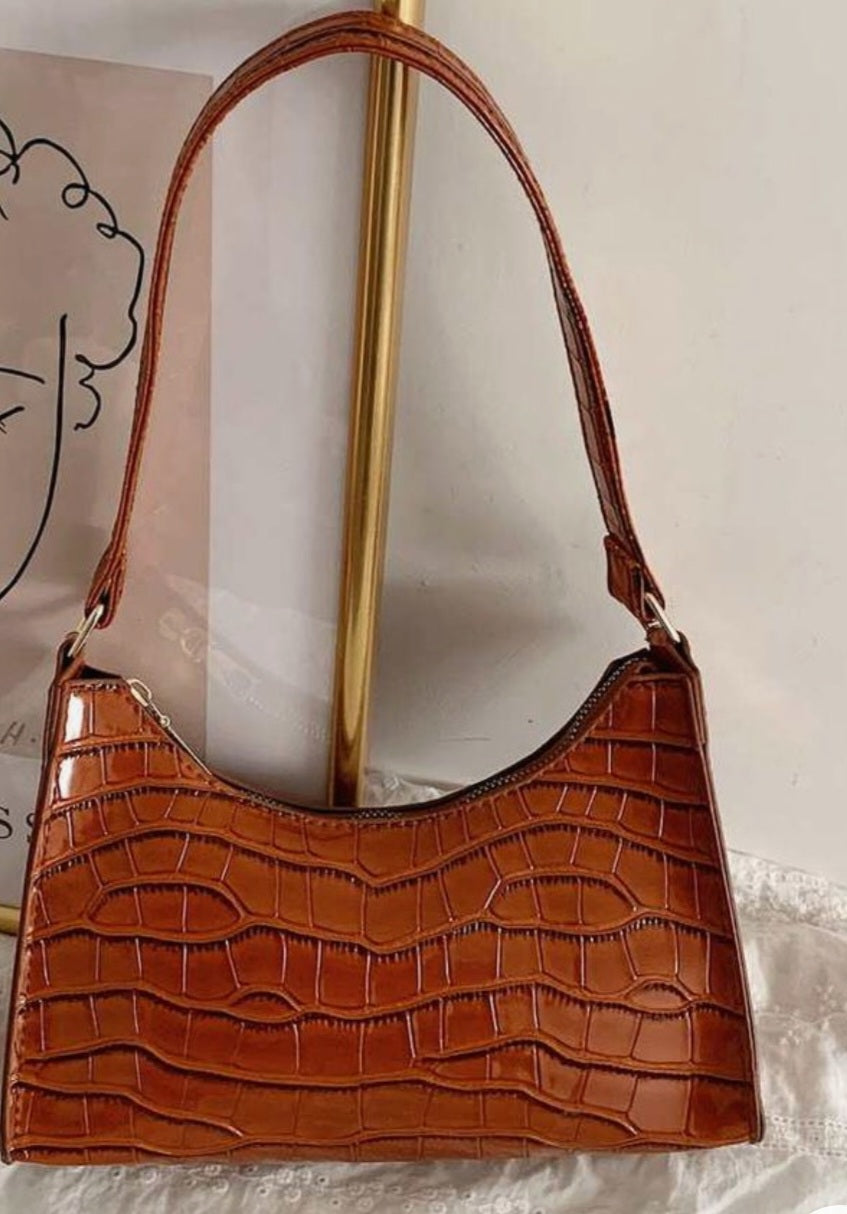 A green croc embossed vegCroc Embossed Classic Clutch Bag vegan leather women's handbag on plain backgroundan leather shoulder bag with a zipper closure and a shoulder strap.