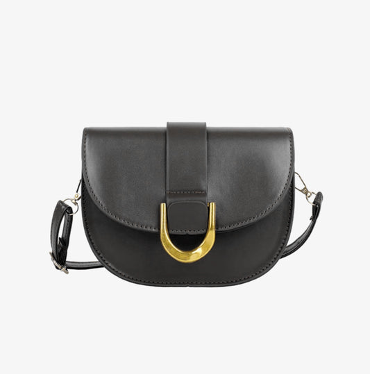 A black crossbody bag with a gold-tone buckle and a smooth solid texture. It features a front flap, a handle, and a detachable strap.