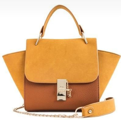 Two-toned handbag with mustard yellow top section and brown bottom section on a white background
