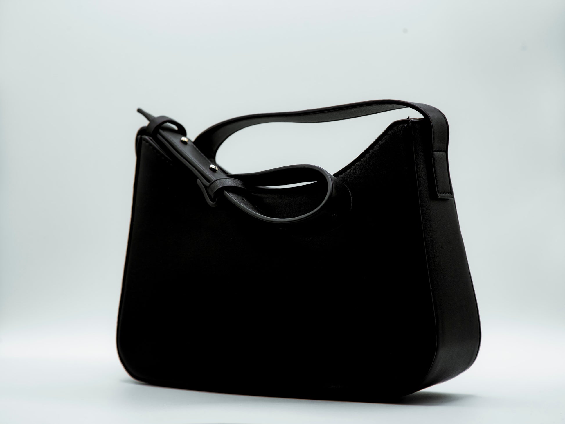Black handbag on a light gray background