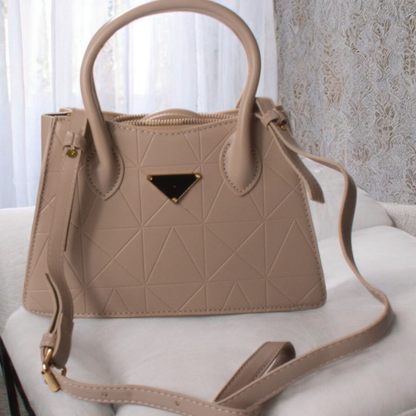Beige handbag with geometric pattern on a white surface