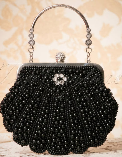 Luxurious black evening clutch purse featuring pearl embellishments and a sparkly metallic handle.