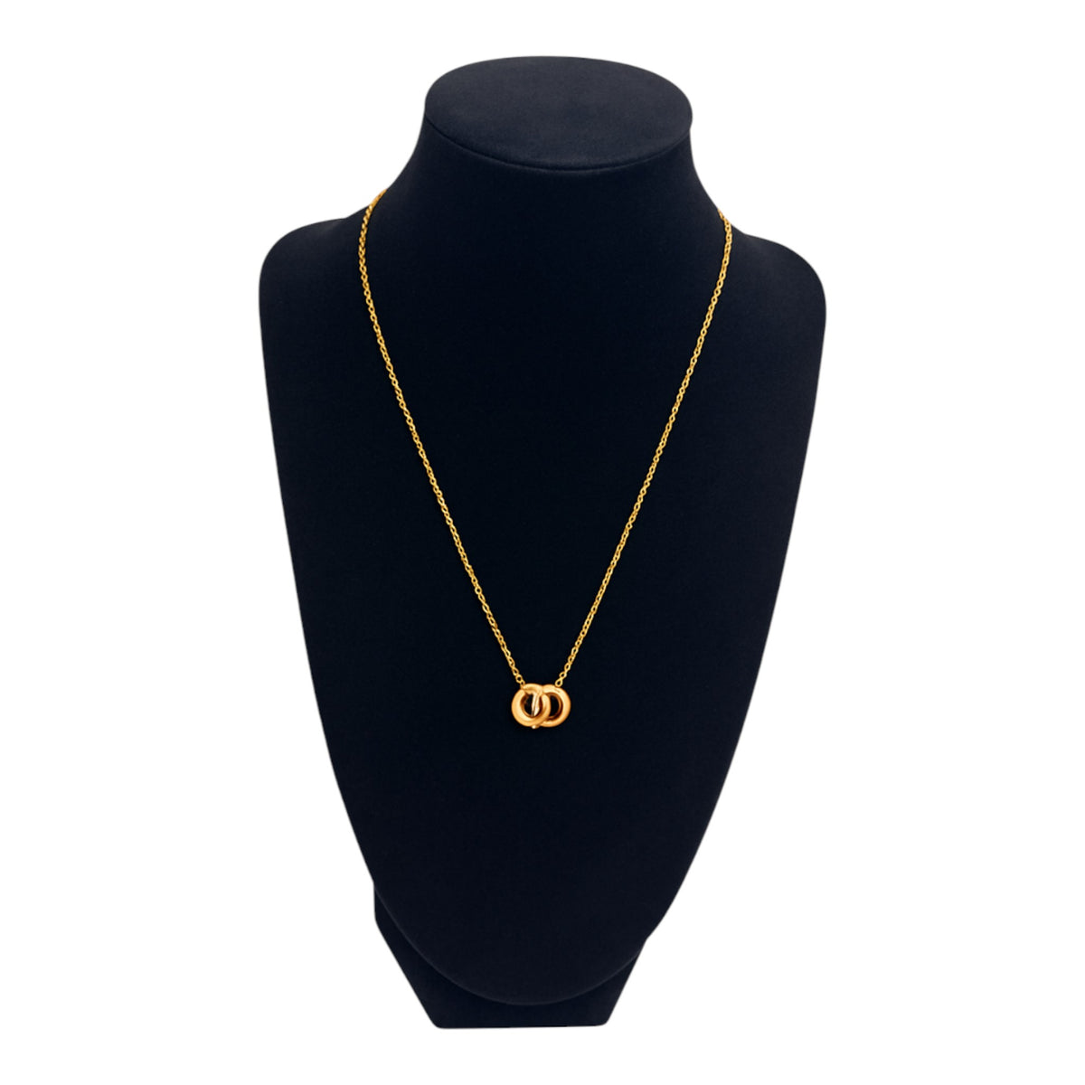 Gold necklace on a black mannequin bust with a white background